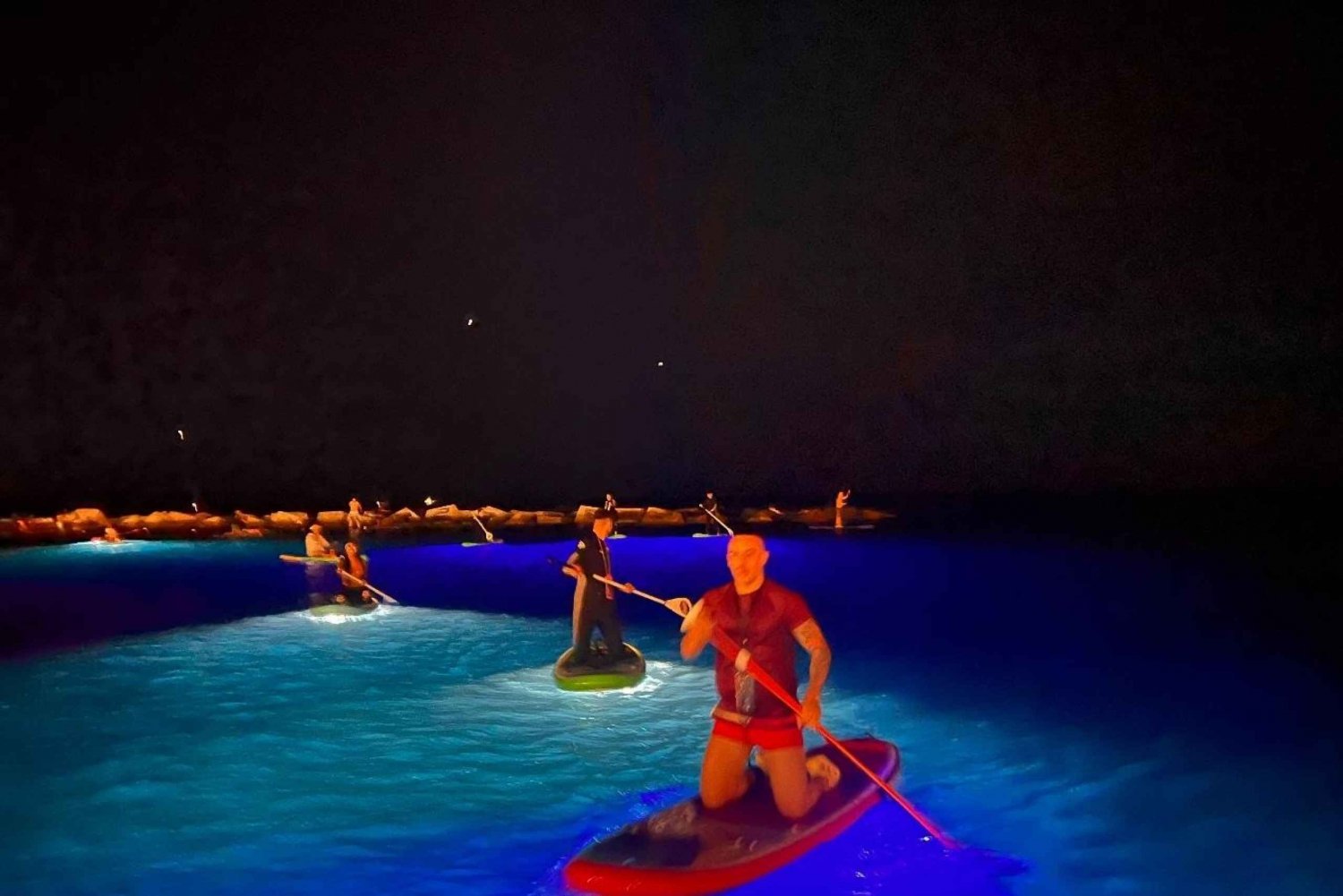 Padlesurfing om natten med lys og drikke -bilder og videoer