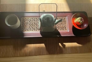 Cerimónia do chá chinês no pátio de Hutong de Pequim