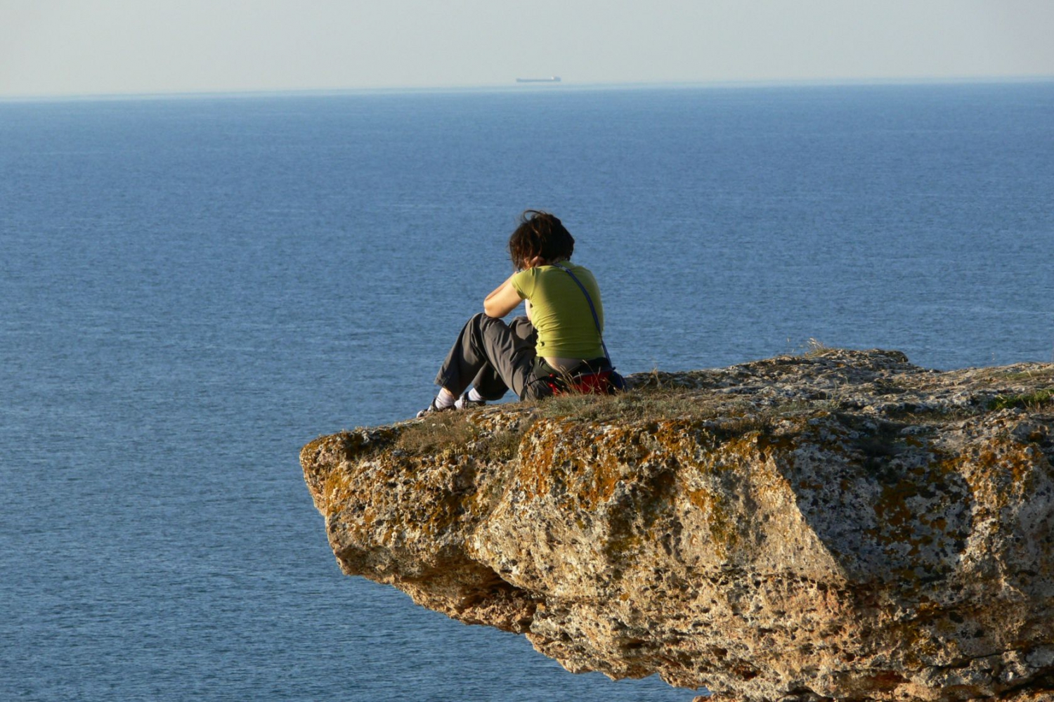 A girl enjoys the sea view from the cliffs