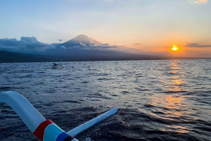 Jukung-rondvaart tijdens zonsondergang in Amed, Bali, met de berg Agung op de achtergrond