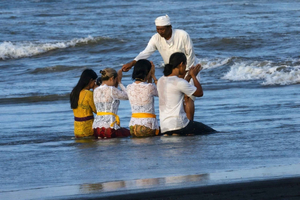 Sanur: rituale balinese di purificazione nell'oceano con un sacerdote