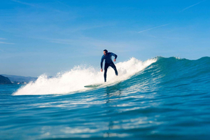 Clase colectiva de surf en la playa de Milady