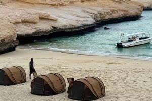Mascate: acampamento de praia durante a noite com churrasco