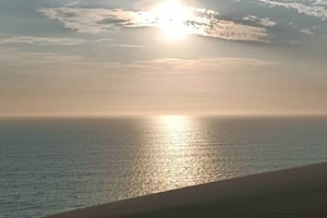 Sandwich Harbour: zonsondergang, duinenrit en oceaan