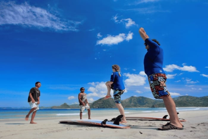 Clase de surf para principiantes en Lombok con playa y atardecer