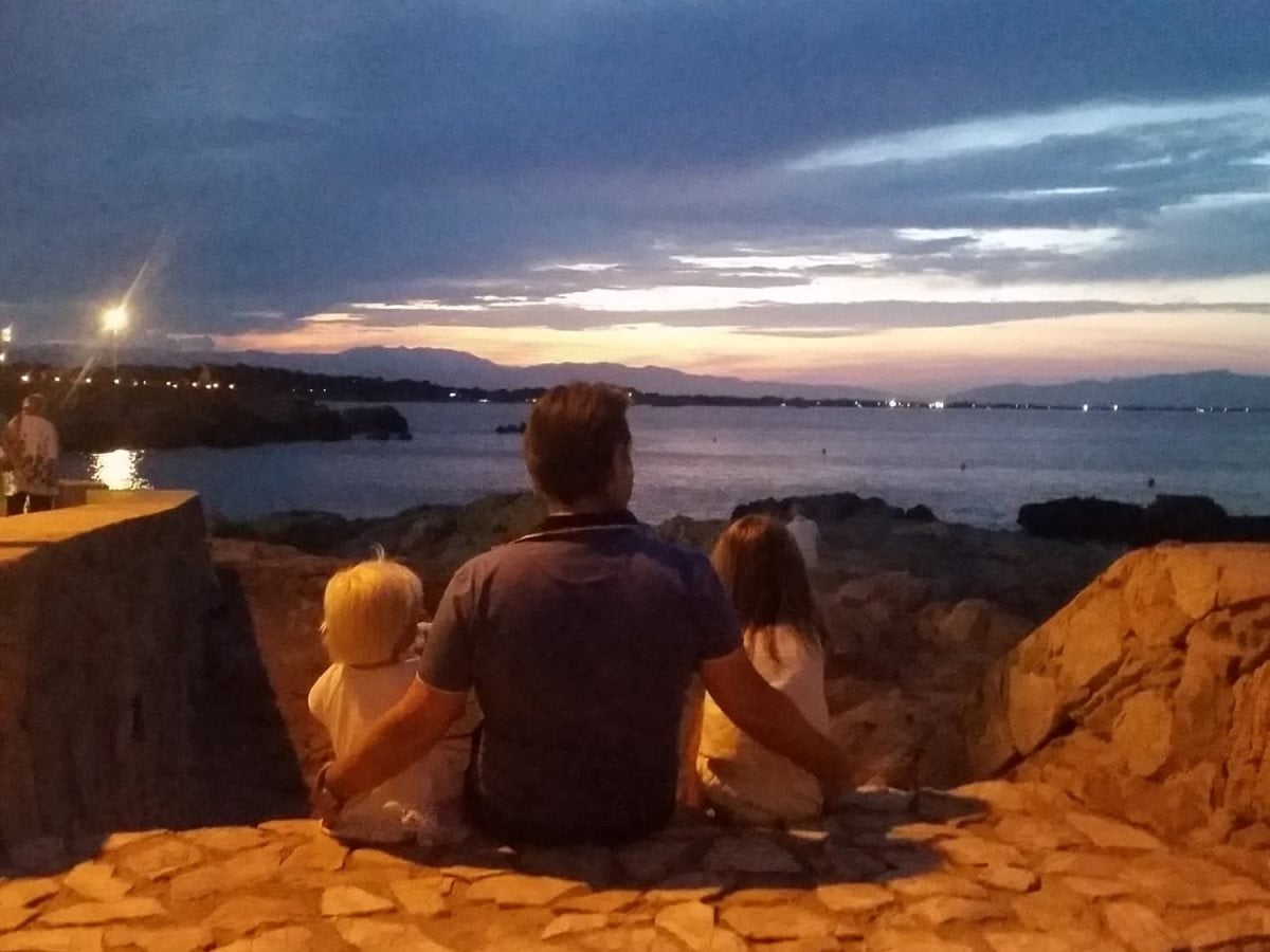 Mark and his children watching the sunset over the sea