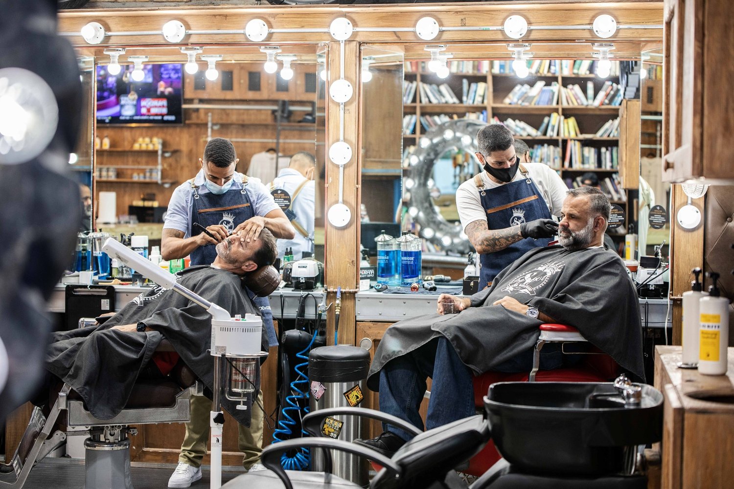 A person getting a haircut in a barber shop

Description automatically generated