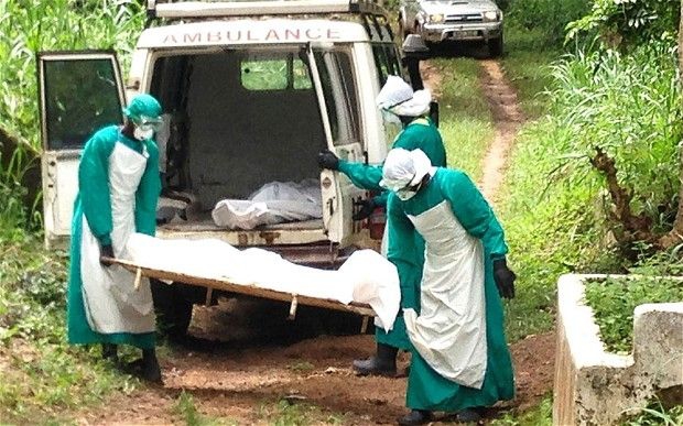 health workers deposing the corpse of an ebola patient  