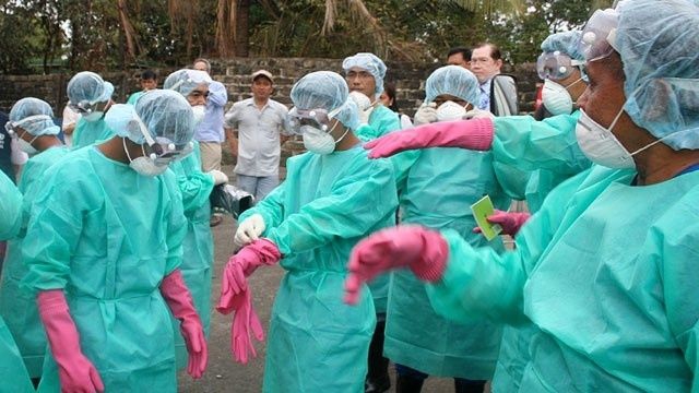 Health Workers putting on their protective suit