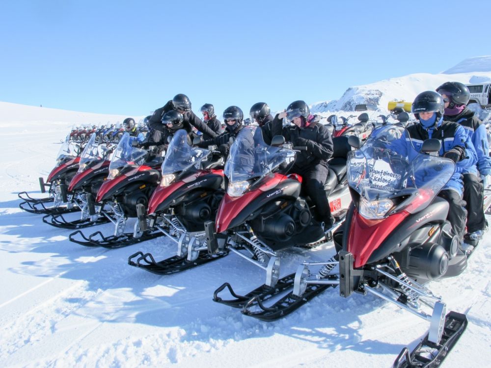 Snowmobiles waiting to set off to explore a glacier on a day trip from Reykjavik, Iceland