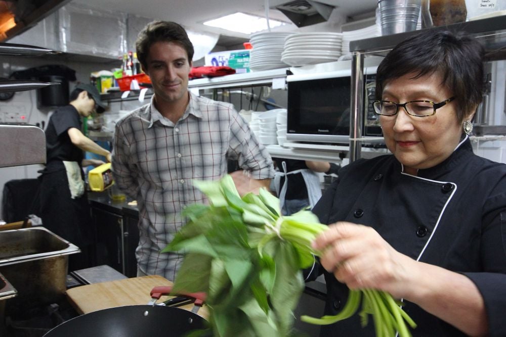 Violet Oon showing Alex how to clean sweet potato leaves